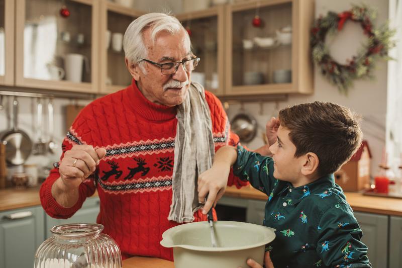A Grandfather teaches his grandson how to cook.