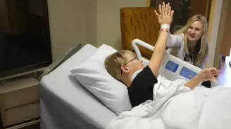 Doctor and Young Patient High Five from a Hospital Bed