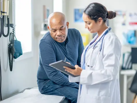 A middle-aged man talking to his doctor.