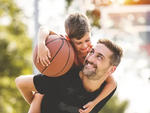 A man holding his son on his shoulders.