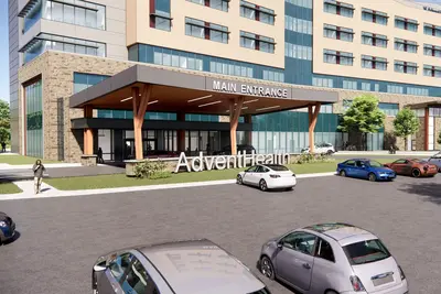 Architectural rendering of an AdventHealth facility main entrance with a covered drive-through canopy, large white AdventHealth signage in the foreground, and a multi-story hospital building with beige and glass exterior