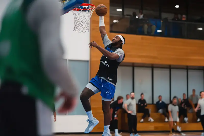 An Orlando Magic player dunking a basketball.