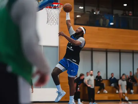 An Orlando Magic player dunking a basketball.