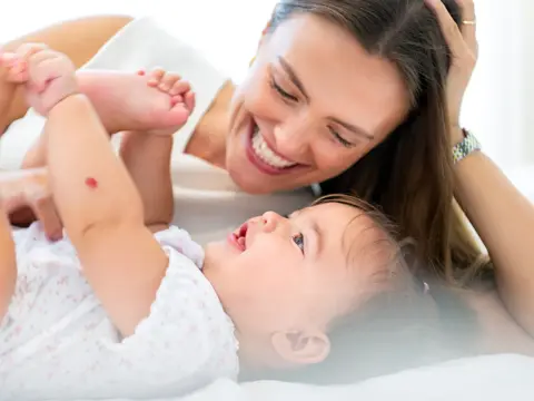 A young mother playing with her baby.