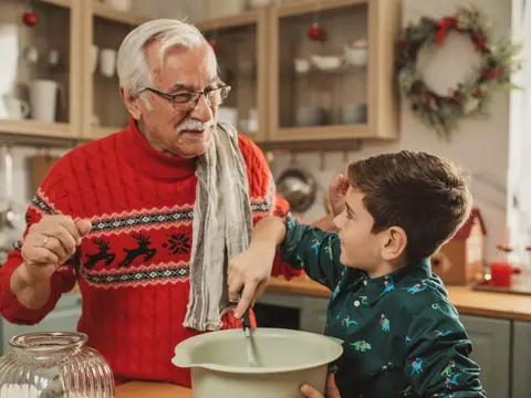 A Grandfather teaches his grandson how to cook.