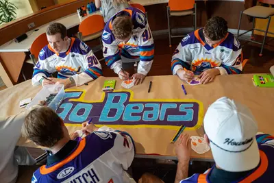 The Orlando Solar Bears coloring-in logos on a table.