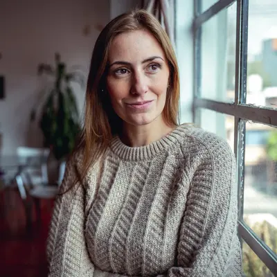 A woman looking out a window, smiling.