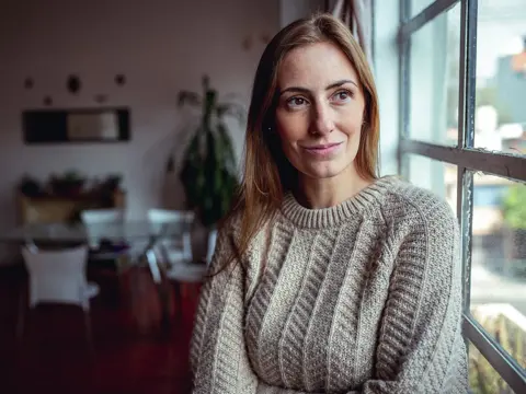 A woman looking out a window, smiling.