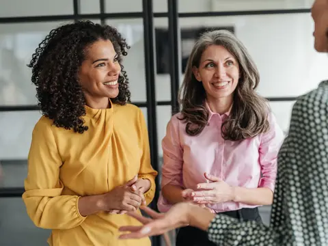 Three woman having a conversation.