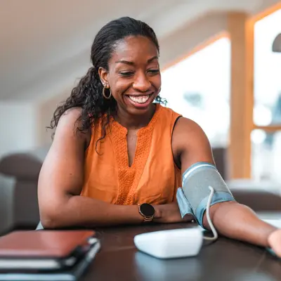 A woman checking her blood pressure at home.