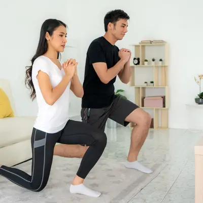 A couple exercising in the living room. 