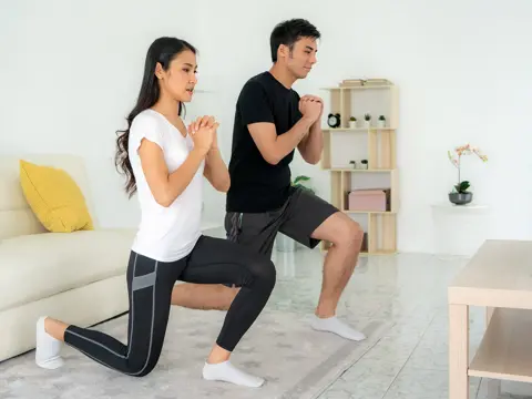 A couple exercising in the living room. 