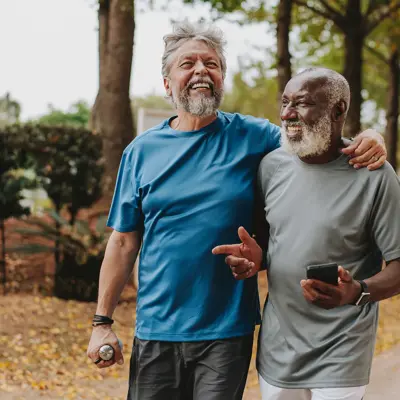 Two older men walking outdoors.