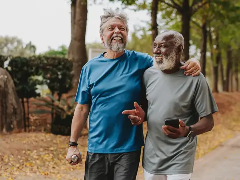 Two older men walking outdoors.
