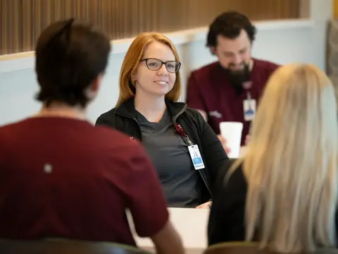 A group of people are sitting around a table, engaged in conversation.