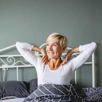 Senior woman wake up and she is stretching in bed