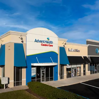 AdventHealth Centra Care building with blue awnings and FedEx Office next door.