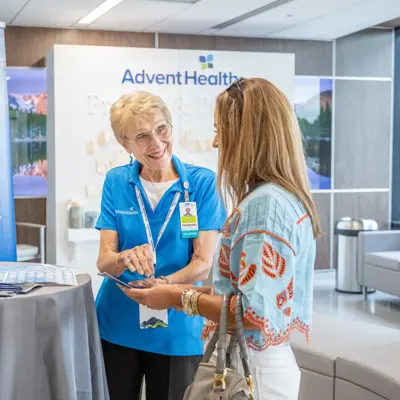 Event staff at the grand opening of the AdventHealth Heart and Vascular Institute greet a guest.