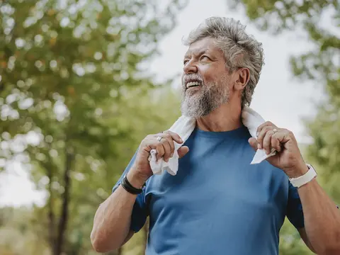 An older man taking a break from exercising outdoors.