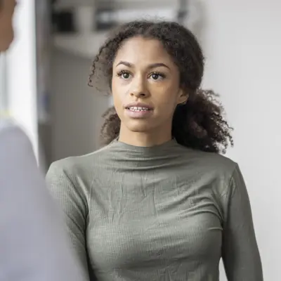Women is speaking to their physician in a medical office.