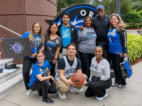 A group of people wearing Orlando Magic gear.