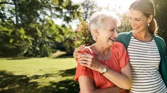 A young woman going for a walk with her elderly mother in the garden