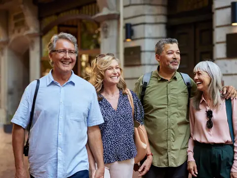 A middle-aged group of people walking through the city.