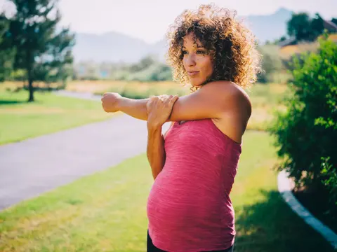 A pregnant woman stretching.
