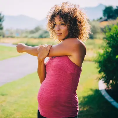 A pregnant woman stretching.