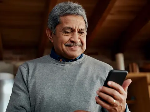 An older man looking at his phone.