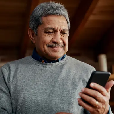 An older man looking at his phone.