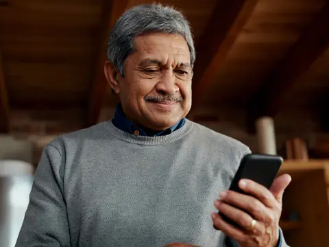 An older man looking at his phone.