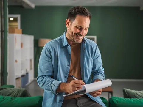 A man writing on a notepad.