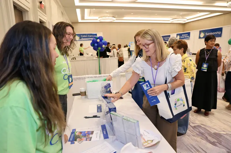 Attendee gathering health information from AdventHealth team members at the Women’s Health and Cancer Prevention Event.