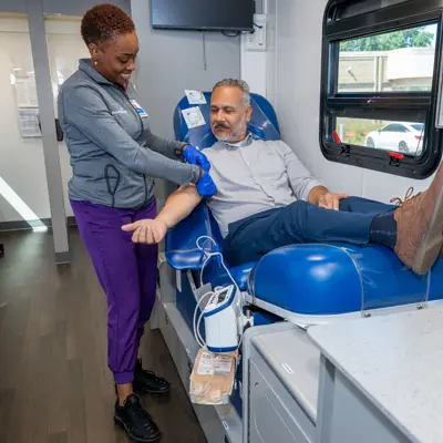 A nurse is preparing a patient for a blood draw in a medical setting.