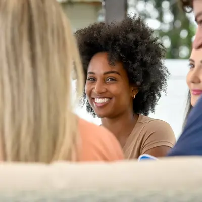Group of people smiling and engaging in conversation, showcasing a warm and inviting atmosphere.
