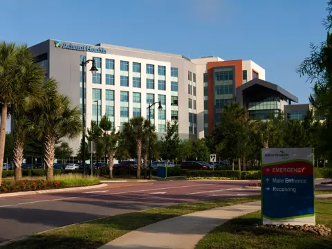AdventHealth building with emergency entrance sign and parking lot.