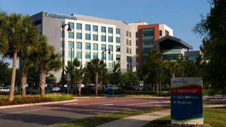 AdventHealth building with emergency entrance sign and parking lot.