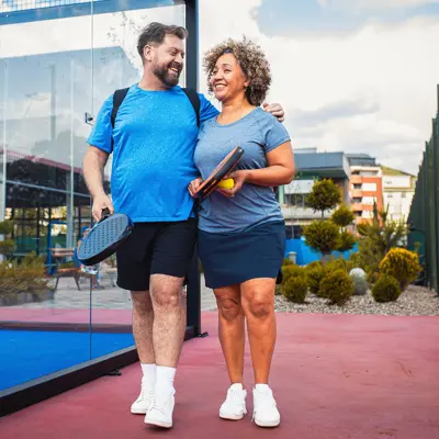 A couple walking together at a pickelball court,
