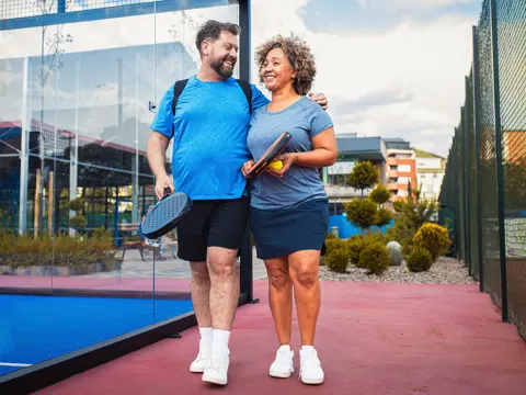 A couple walking together at a pickelball court,