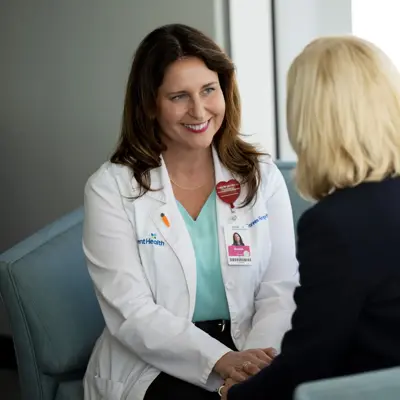 Health navigator sitting with female patient.