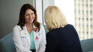 Health navigator sitting with female patient.