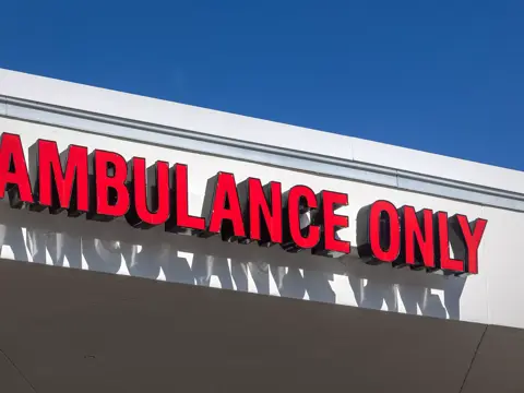 Red sign on a building reads 'Ambulance Only' in bold letters.
