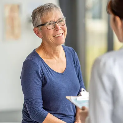 An older woman speaks to a female healthcare provider.