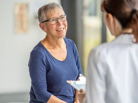 An older woman speaks to a female healthcare provider.