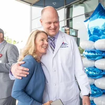 People side hug at the grand opening of the AdventHealth Heart and Vascular Institute
