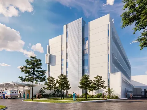 Exterior architectural rendering of the AdventHealth Carrollwood Garden Tower expansion showing a modern multi-story medical facility with white facade, landscaped grounds, ambulance bay, and people walking near the entrance