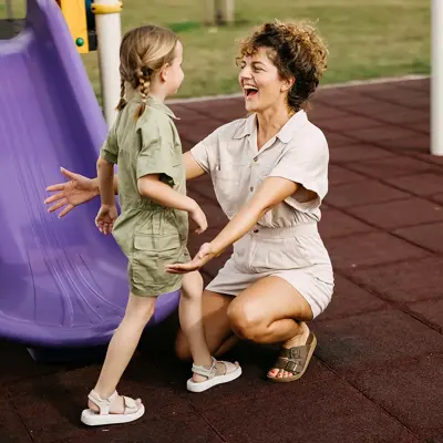 A mother and daughter having fun at a playground.