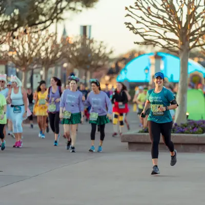 A female runner at a RunDisney Event in the early morning.