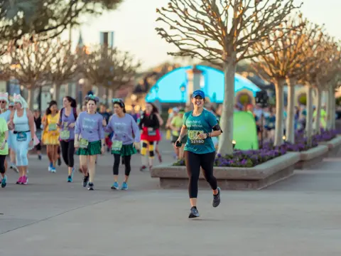 A female runner at a RunDisney Event in the early morning.